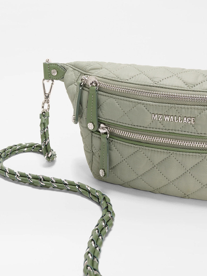 An MZ Wallace Small Crosby Sling Bag in Agave Green Oxford, featuring a quilted design, silver zippers, logo details, and a braided chain strap, shown on a white background.