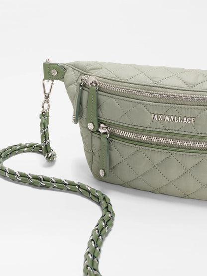 An MZ Wallace Small Crosby Sling Bag in Agave Green Oxford, featuring a quilted design, silver zippers, logo details, and a braided chain strap, shown on a white background.