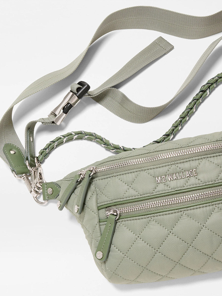 The MZ Wallace Small Crosby Sling Bag in Agave Green Oxford features a quilted design, silver zippers, braided accents, and the "MZ WALLACE" logo on the front.