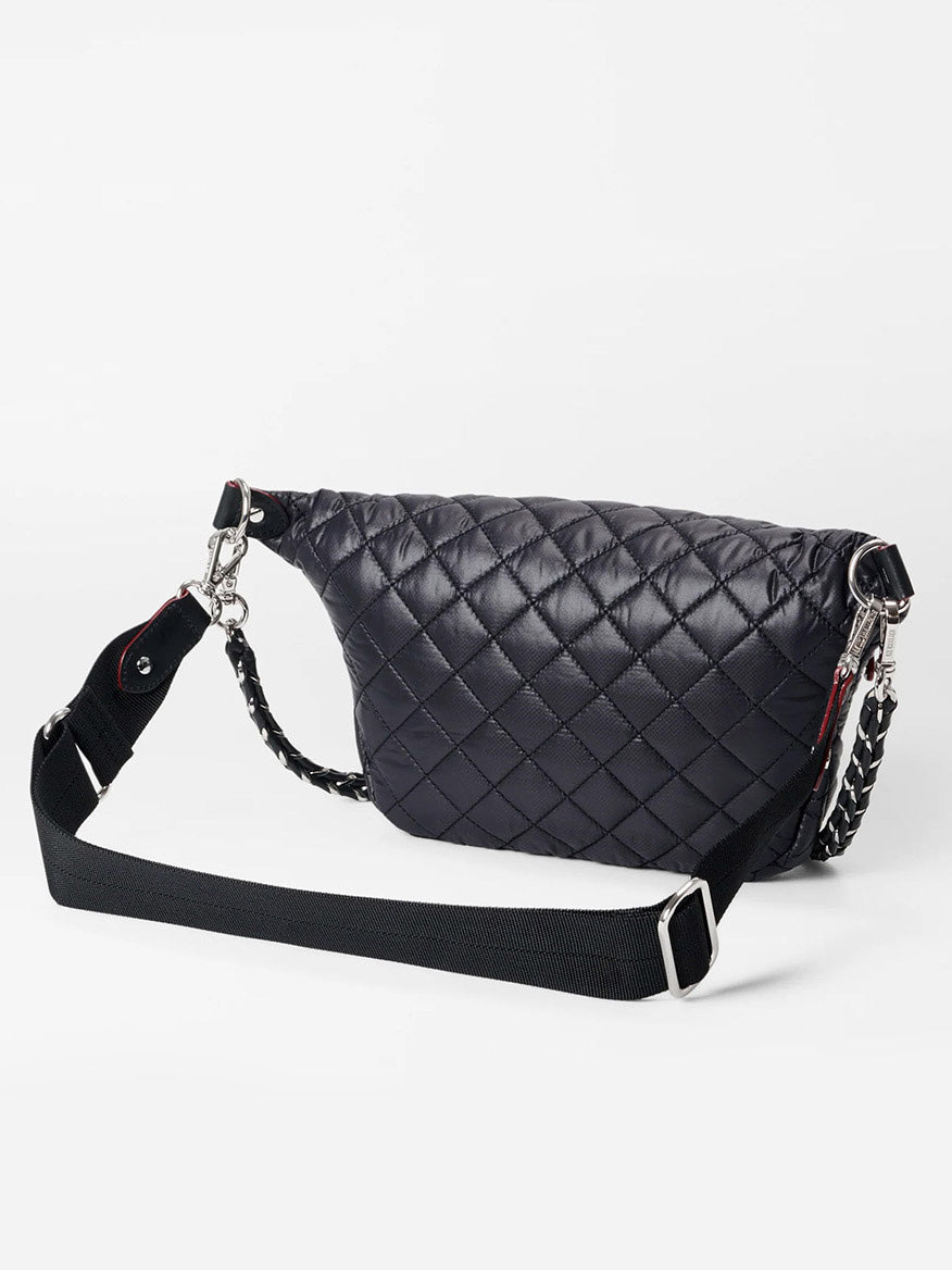 The MZ Wallace Small Crosby Sling Bag in Black Oxford is a black quilted leather crossbody bag with silver hardware and an adjustable strap. Its sleek design is enhanced by exterior pockets, all displayed against a pristine white background.