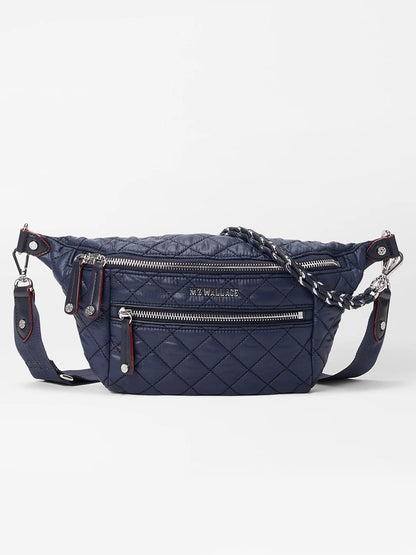 The MZ Wallace Small Crosby Sling Bag in Dawn Oxford, featuring silver zippers, a front zip pocket, and a detachable strap, is displayed against a white background.