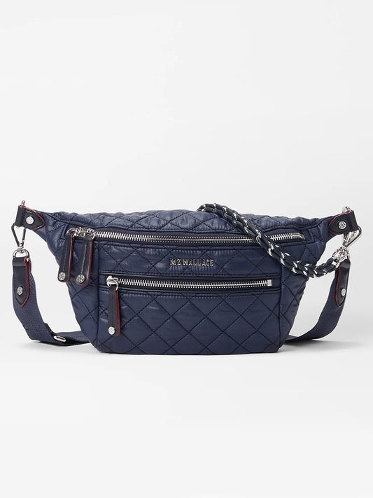 The MZ Wallace Small Crosby Sling Bag in Dawn Oxford, featuring silver zippers, a front zip pocket, and a detachable strap, is displayed against a white background.