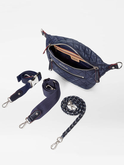The MZ Wallace Small Crosby Sling Bag in Dawn Oxford is a navy quilted crossbody with an open zipper, three detachable straps (including one braided), and silver hardware, displayed on a white background.