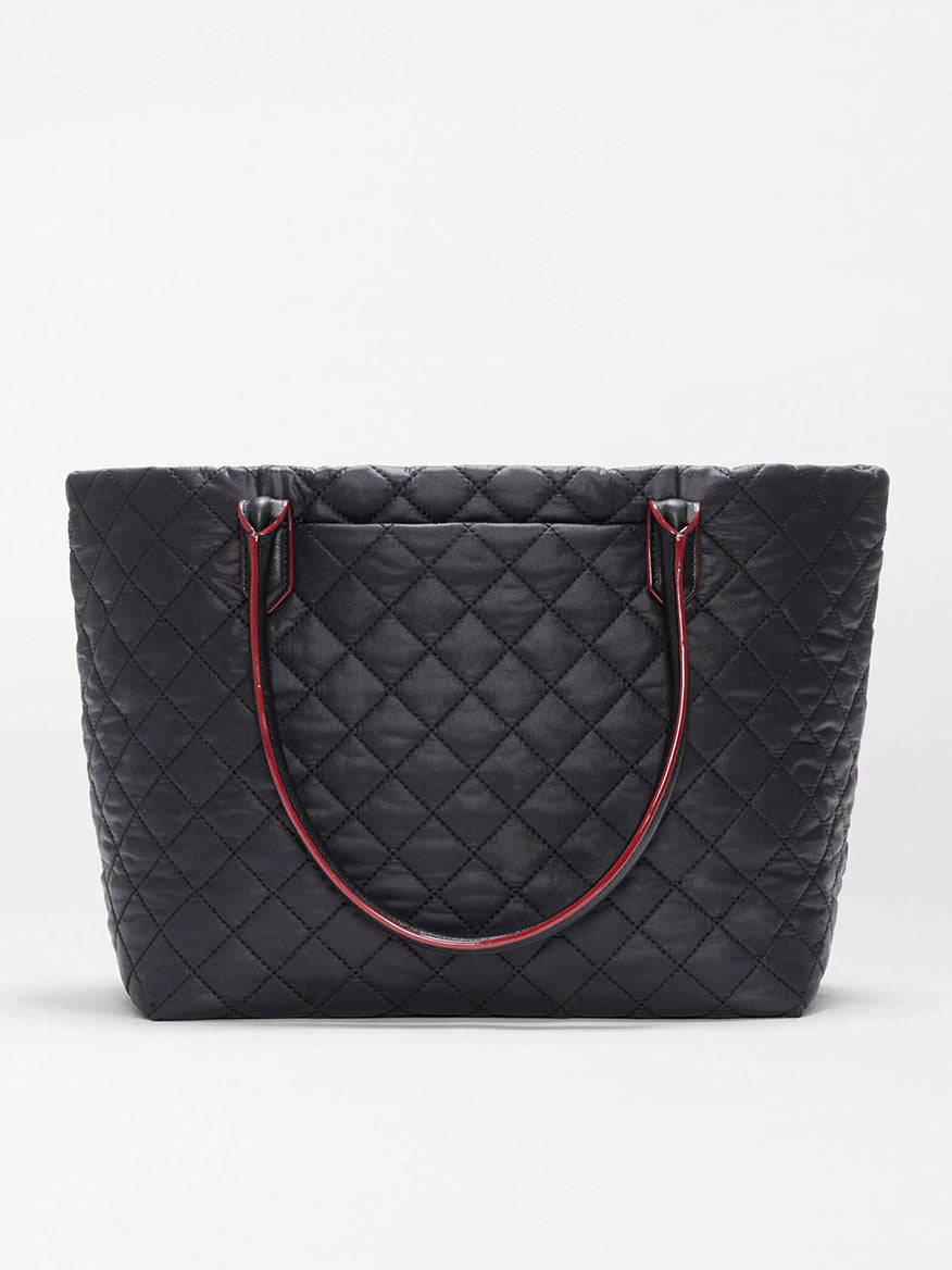 The MZ Wallace Small Daily Tote in Black Oxford is a black tote made from quilted recycled nylon, featuring double shoulder straps with red edging, shown against a plain white background.