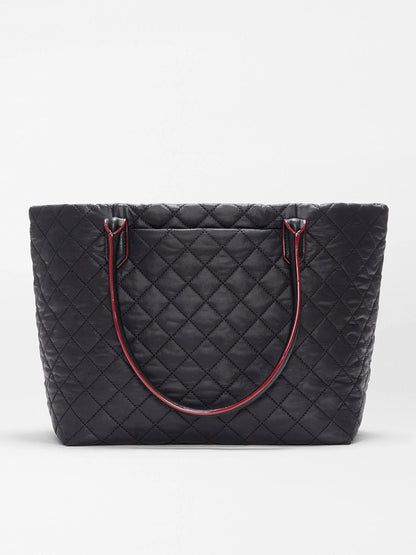 The MZ Wallace Small Daily Tote in Black Oxford is a black tote made from quilted recycled nylon, featuring double shoulder straps with red edging, shown against a plain white background.