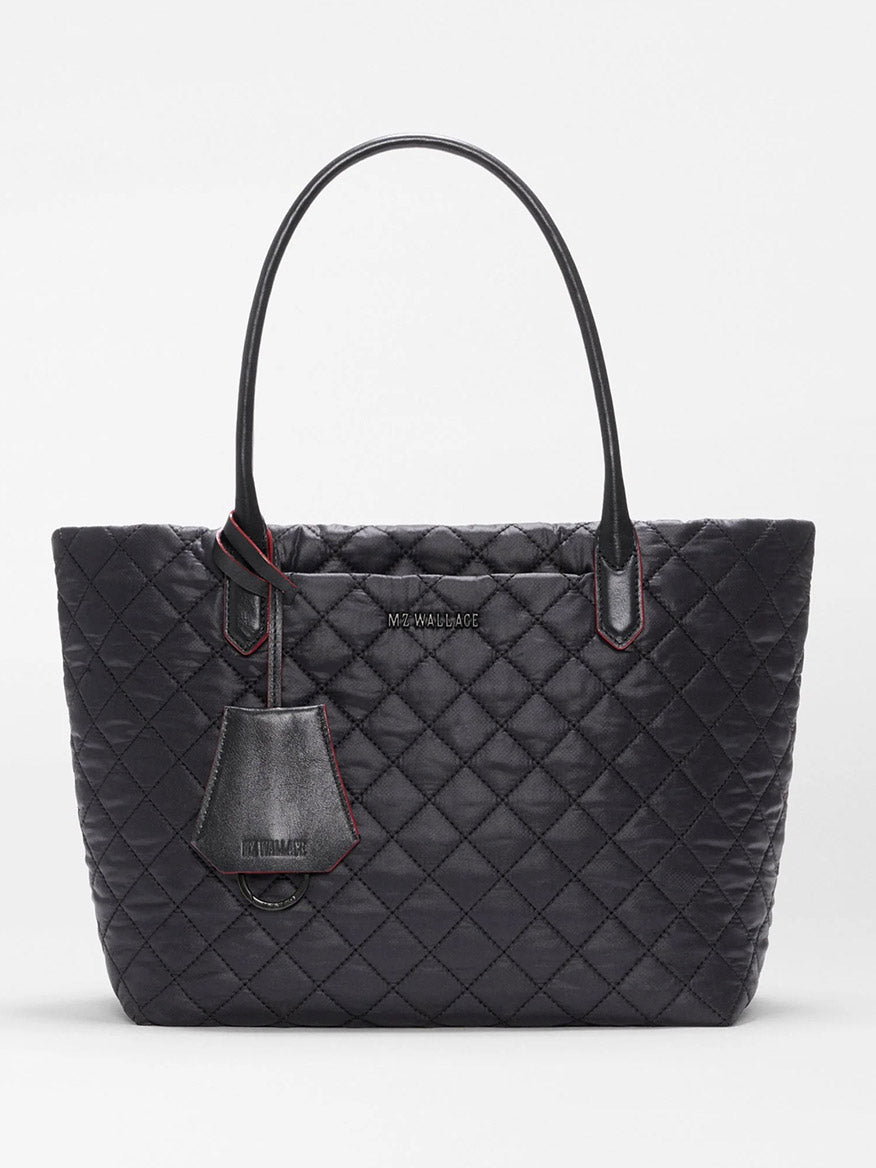 MZ Wallace Small Daily Tote in Black Oxford, crafted from recycled nylon with a quilted finish, features two handles, a front logo, and a matching hanging tag, shown against a plain white background.