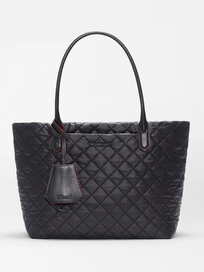 MZ Wallace Small Daily Tote in Black Oxford, crafted from recycled nylon with a quilted finish, features two handles, a front logo, and a matching hanging tag, shown against a plain white background.
