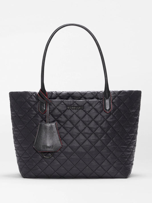 MZ Wallace Small Daily Tote in Black Oxford, crafted from recycled nylon with a quilted finish, features two handles, a front logo, and a matching hanging tag, shown against a plain white background.