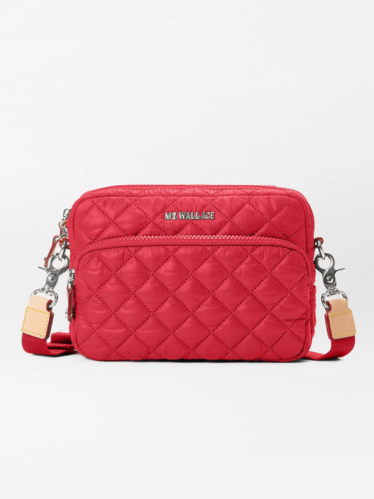 The MZ Wallace Small Metro Camera Bag in Apple Oxford is a lightweight, stylish nylon crossbody featuring silver hardware, beige leather accents, and the "MZ WALLACE" logo on the front.