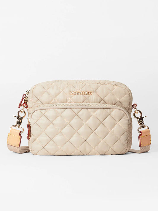 MZ Wallace Small Metro Camera Bag in Buff Oxford features a quilted design, lightweight nylon crossbody strap, metal clasps, and a front zip pocket.