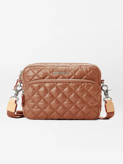 The MZ Wallace Small Metro Camera Bag in Terracotta Oxford is a lightweight, brown nylon crossbody handbag with quilting, featuring a zippered pocket and an adjustable, chic two-tone strap perfect for everyday use.