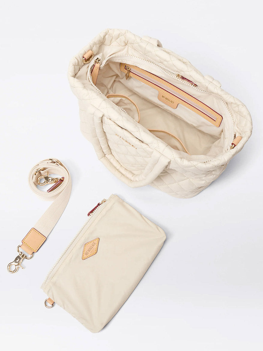 The MZ Wallace Small Metro City Tote in Sandshell Oxford features a cream quilted exterior, open top with interior pockets, and comes with a matching detachable strap and removable zip pouch.