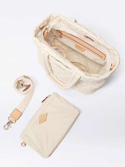 The MZ Wallace Small Metro City Tote in Sandshell Oxford features a cream quilted exterior, open top with interior pockets, and comes with a matching detachable strap and removable zip pouch.