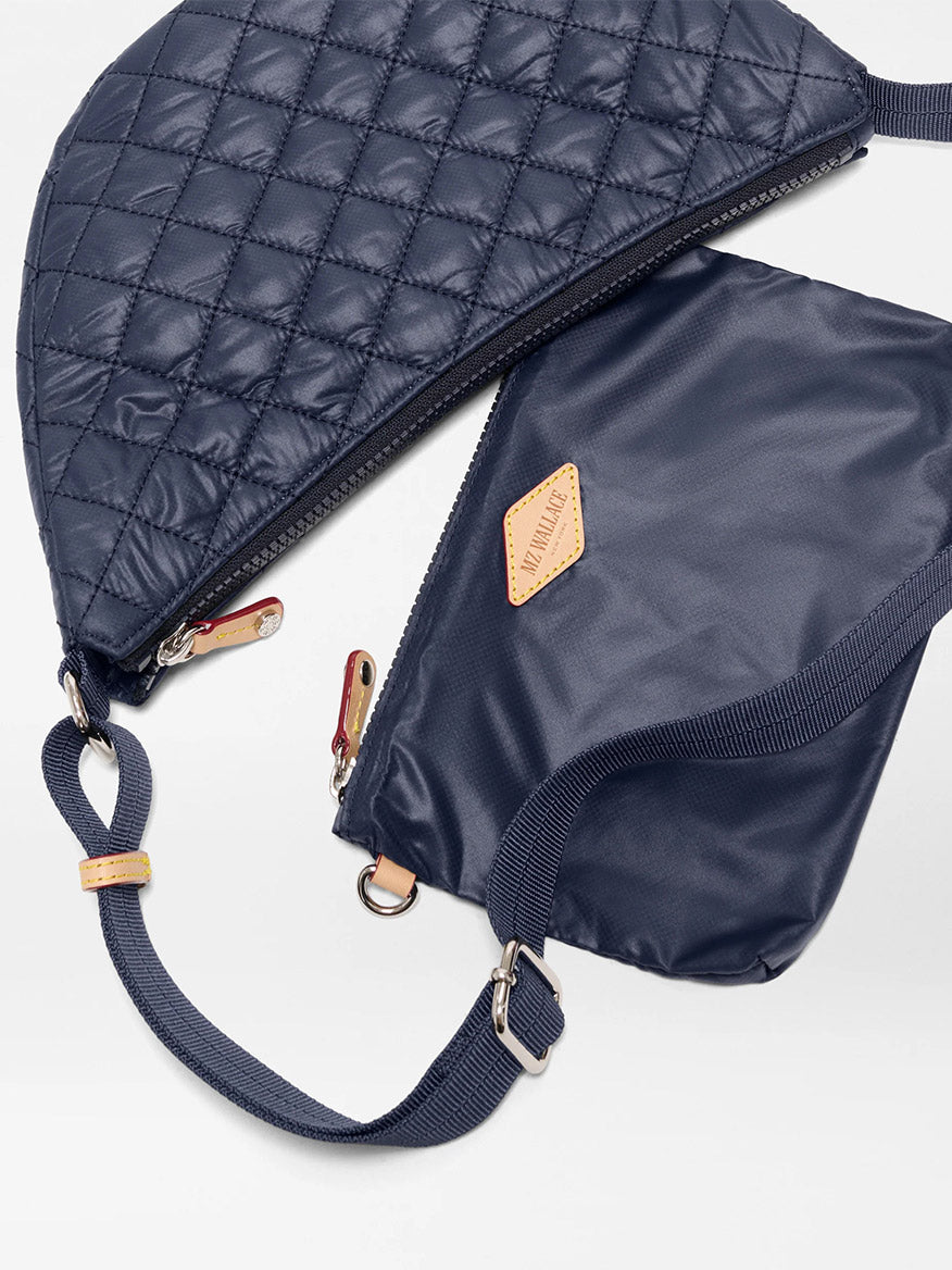 The MZ Wallace Small Metro Smile Bag in Dawn Oxford, featuring zippers, adjustable nylon straps, and Italian leather trim, blends style and function for everyday versatility in a refined navy blue design.