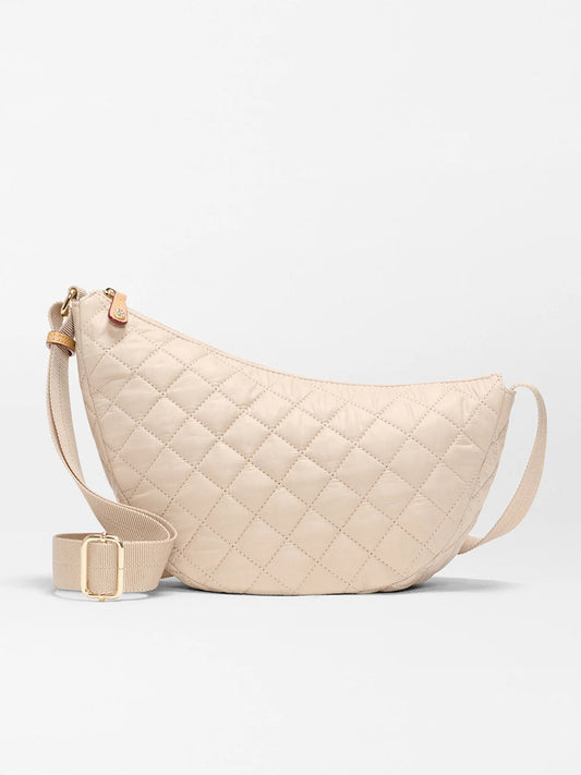 The MZ Wallace Small Metro Smile Bag in Buff Oxford features Italian leather trim, an adjustable nylon strap, and gold-tone hardware, displayed against a plain light background.