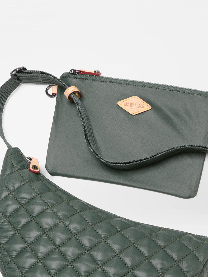 Two green bags, one quilted and one smooth, featuring a strap and a tan MZ Wallace logo patch, are displayed on a white background. The MZ Wallace Small Metro Smile Bag in Juniper Oxford is crafted from recycled nylon for an eco-friendly touch, making it the perfect green crossbody bag for everyday style.