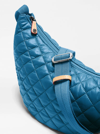 Close-up of the MZ Wallace Small Metro Smile Bag in Atlantic Blue Oxford, crafted from recycled oxford nylon with quilted detailing, a zipper closure, an adjustable strap with metal buckle and leather accent—perfect for everyday crossbody carry.