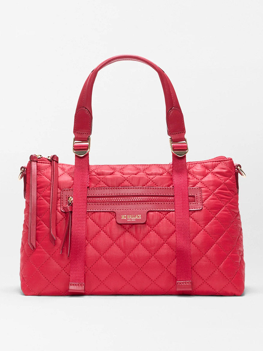 The MZ Wallace Small Park Satchel in Apple Oxford features quilted red fabric, two top handles, a front zipper pocket, and a rectangular logo plaque—perfect for stylish outings.