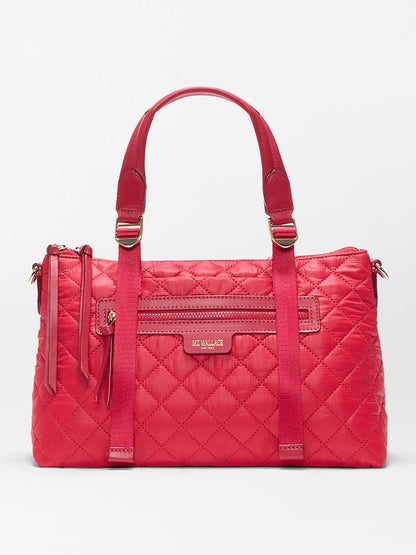 The MZ Wallace Small Park Satchel in Apple Oxford features quilted red fabric, two top handles, a front zipper pocket, and a rectangular logo plaque—perfect for stylish outings.