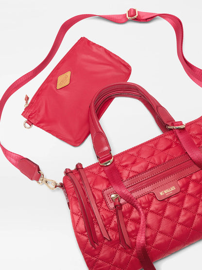 The MZ Wallace Small Park Satchel in Apple Oxford, featuring gold hardware and a matching detachable strap, is paired with a small red zippered pouch for a stylish and versatile crossbody option.