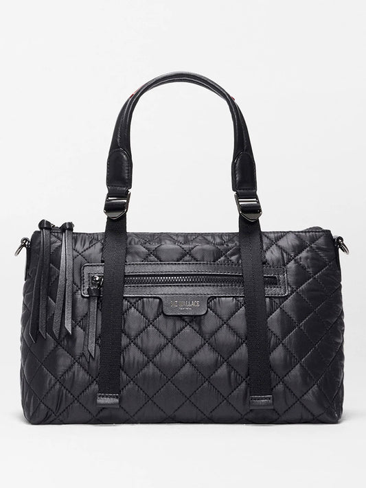 The MZ Wallace Small Park Satchel in Black Oxford features a compact black quilted design, two handles, a front zip pocket, decorative tassels, and a subtle brand label—perfect as an everyday bag.