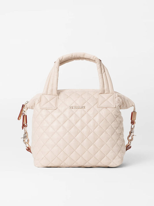 A beige MZ Wallace Small Sutton Deluxe in Mushroom Oxford quilted handbag with nylon handles, and a detachable crossbody strap.