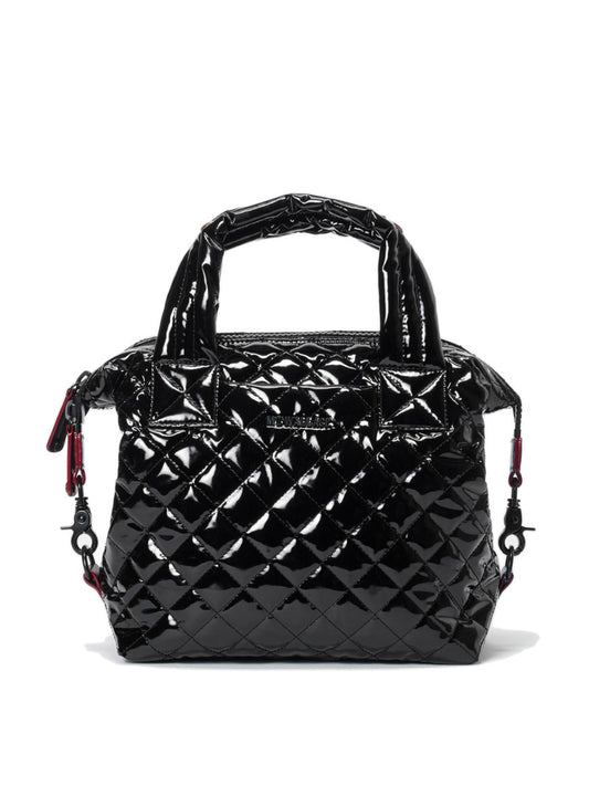 The MZ Wallace Small Sutton Deluxe in Black Lacquer Oxford, featuring short handles, side clips, Italian leather trim, and a zip closure, is displayed against a white background.