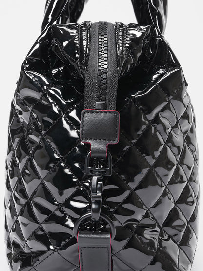 Close-up of the MZ Wallace Small Sutton Deluxe in Black Lacquer Oxford, featuring a glossy quilted finish, Italian leather trim, front zipper, and metal clasp.