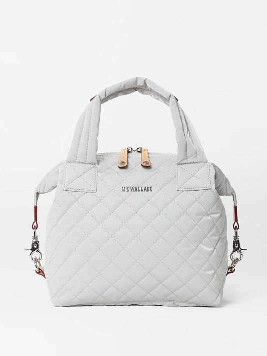 Quilted light gray MZ Wallace Small Sutton Deluxe tote bag in Pebble Liquid Oxford with dual handles and brand insignia, featuring Italian leather trim.