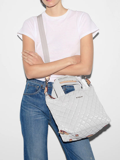 Woman in a white t-shirt and blue jeans carrying a MZ Wallace Small Sutton Deluxe in Pebble Liquid Oxford handbag with Italian leather trim.