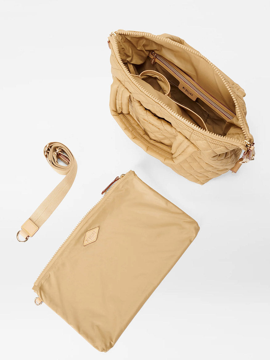 An open Camel Oxford Small Sutton Deluxe handbag with a detachable crossbody strap and a small matching pouch beside it, viewed from above.