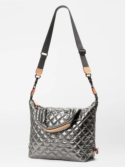 The MZ Wallace Small Sutton Deluxe in Pewter Metallic Oxford is a quilted shoulder bag made from natural Italian leather, featuring an adjustable crossbody strap, a zipper closure, and complemented by a top handle.