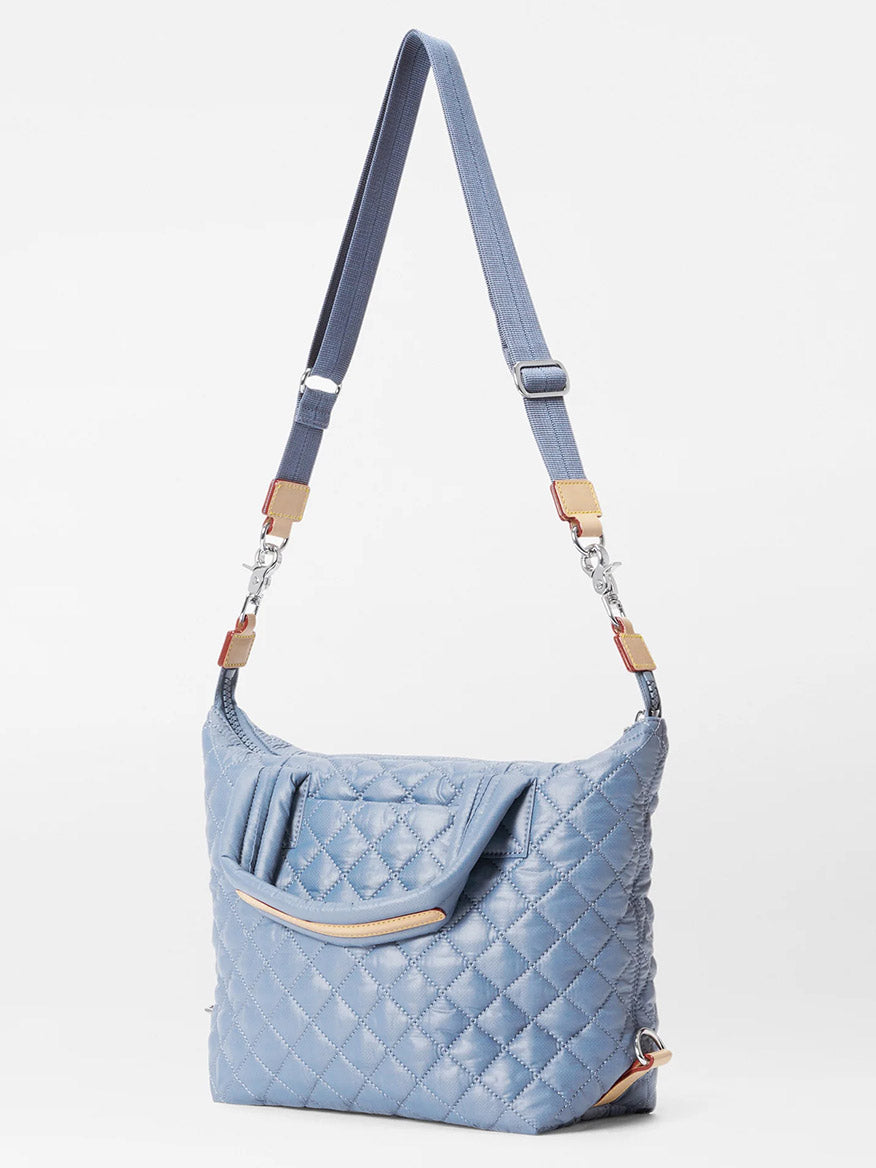 The MZ Wallace Small Sutton Deluxe in Stone Blue Oxford is a quilted shoulder bag with an adjustable crossbody strap, elegant silver hardware, and premium Italian leather.