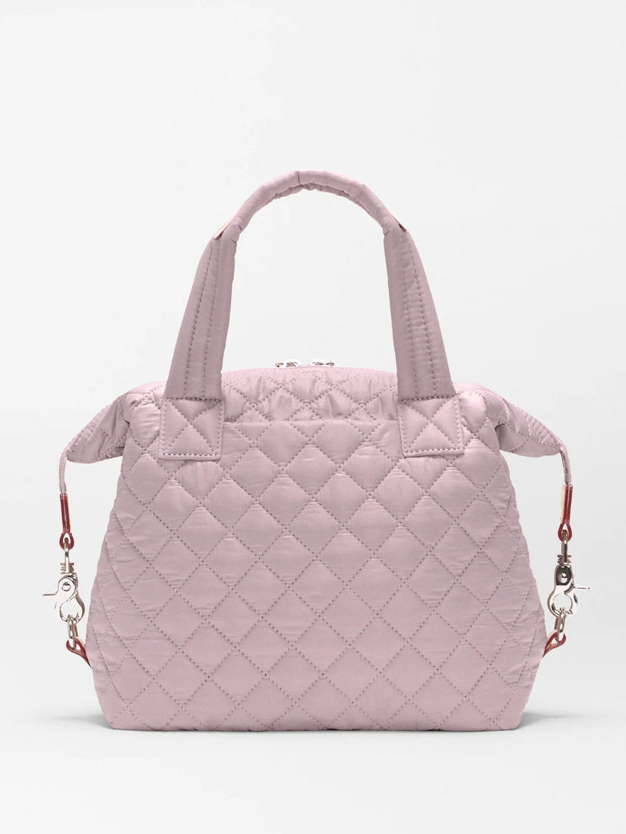 The MZ Wallace Small Sutton Deluxe in Quail Oxford is a light pink quilted convertible tote crossbody with two short handles and detachable shoulder straps, shown against a plain white background.