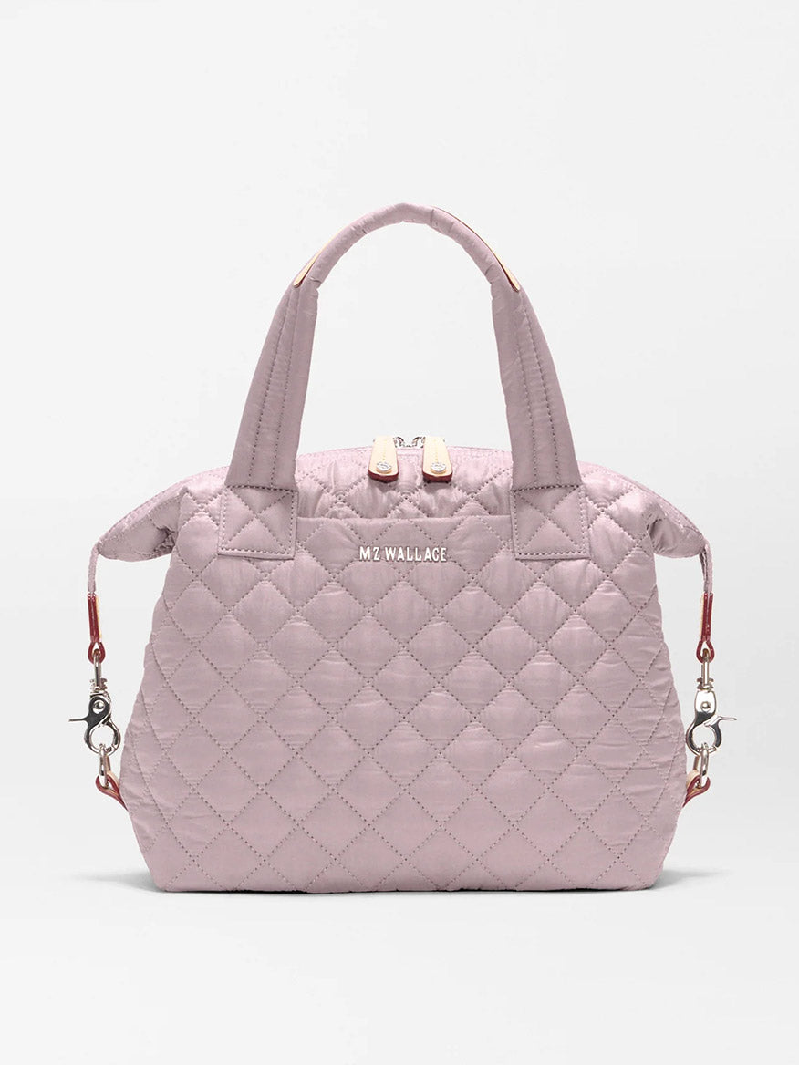 The MZ Wallace Small Sutton Deluxe in Quail Oxford is a light pink quilted recycled nylon bag with two handles, zippered top, detachable shoulder strap for tote or crossbody wear, and features the "MZ WALLACE" logo on the front.