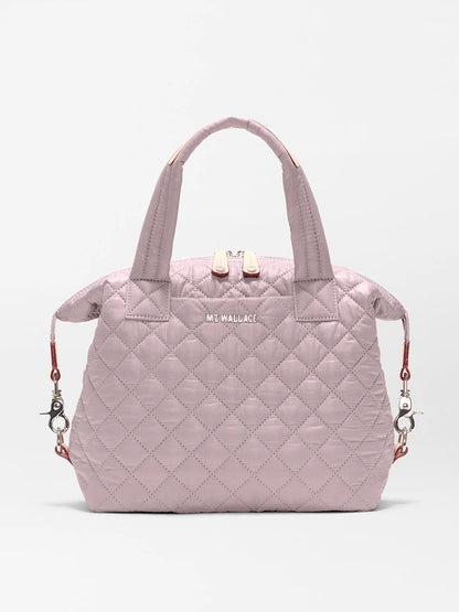 The MZ Wallace Small Sutton Deluxe in Quail Oxford is a light pink quilted recycled nylon bag with two handles, zippered top, detachable shoulder strap for tote or crossbody wear, and features the "MZ WALLACE" logo on the front.