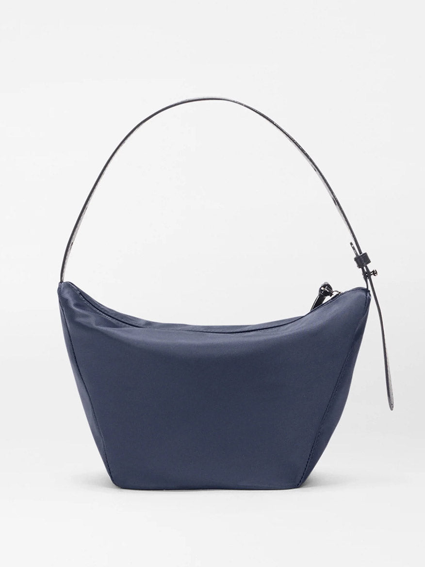 The MZ Wallace Small Waverly Hobo in Dawn Bedford is a navy crescent-shaped handbag with Italian leather, a thin shoulder strap, and zip top closure, displayed on a plain white background.