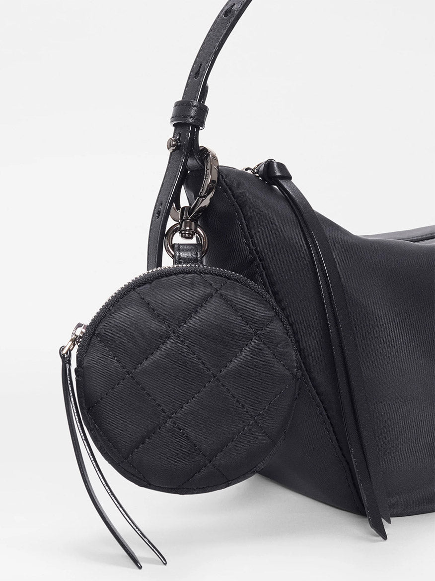 Close-up of the MZ Wallace Small Waverly Hobo in Black Bedford, featuring a black quilted design with Italian leather trim, metal clasp, and matching coin purse attached by a leather strap.