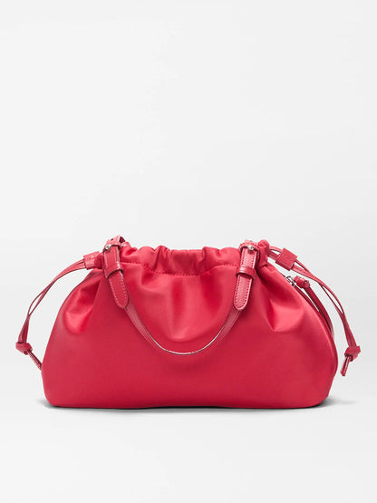 The MZ Wallace Small Waverly Shoulder in Apple Bedford is a bright pink satin bag with a gathered top, double adjustable straps, silver hardware, and a secure magnetic closure, shown against a plain light background.