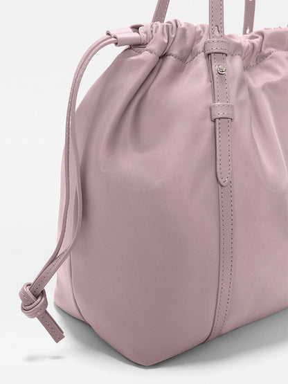A close-up of the MZ Wallace Small Waverly Tote in Quail Bedford, featuring gathered detailing, Italian leather trim, and a side knot on the strap.