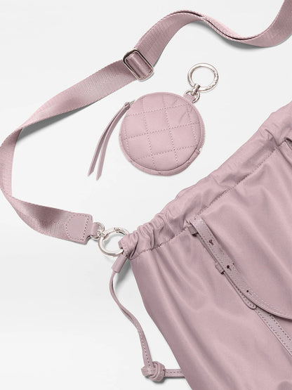 The MZ Wallace Small Waverly Tote in Quail Bedford, a mauve crossbody with Italian leather trim, includes a matching detachable quilted coin pouch and adjustable strap, shown on a white background.