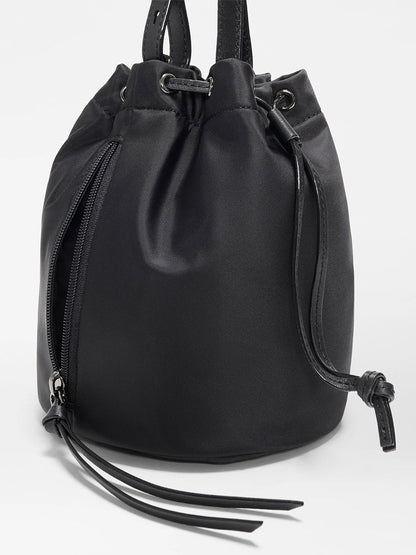 The MZ Wallace Waverly Bucket Bag in Black Bedford features an adjustable nylon strap, side zipper pocket, and thin strap detailing, shown against a plain white background.