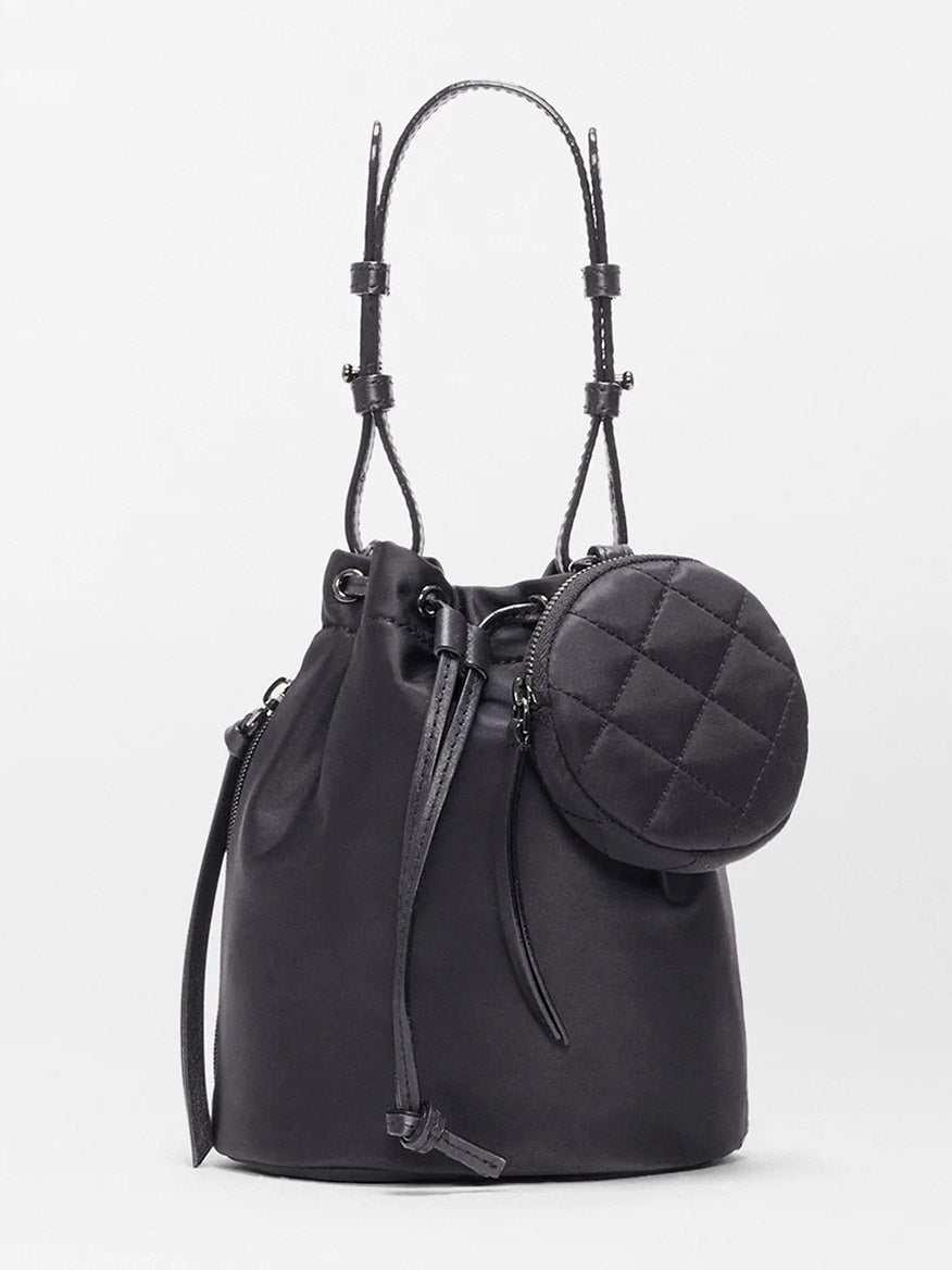 The MZ Wallace Waverly Bucket Bag in Black Bedford features a drawstring closure, shoulder straps, Italian leather trim, and a small round quilted pouch on the front, showcased against a plain light background.