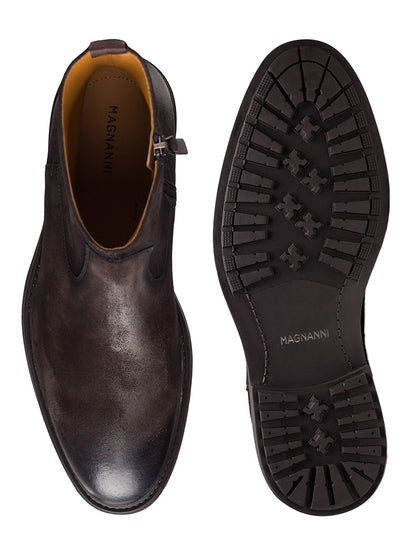The Magnanni Atlas Zip in Waxed Brown Suede men’s ankle boots are shown from above and below, highlighting the smooth suede upper and rugged rubber sole with tread pattern. Handmade in Portugal, these Chelsea boots offer both elegance and lightweight comfort.