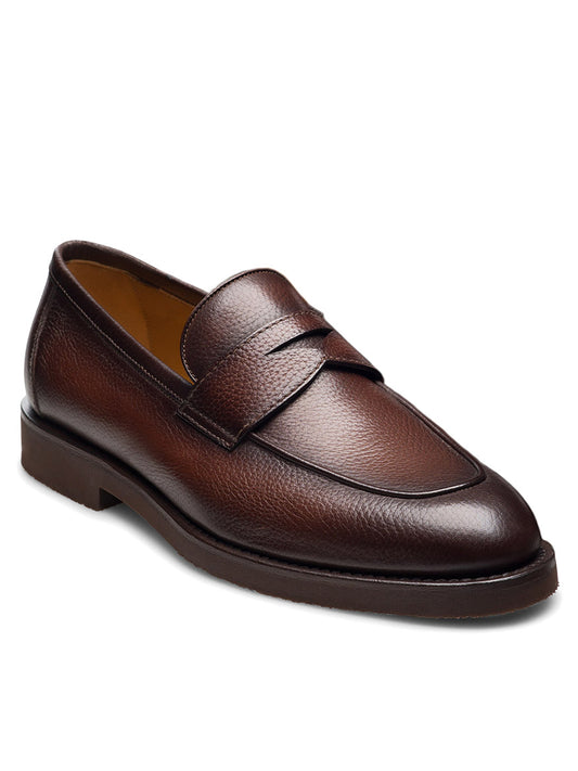 The Magnanni Cervan Penny in Tumbled Brown is a single dark brown leather slip-on loafer, featuring a stitched apron toe and a penny slot strap, displayed on a white background.