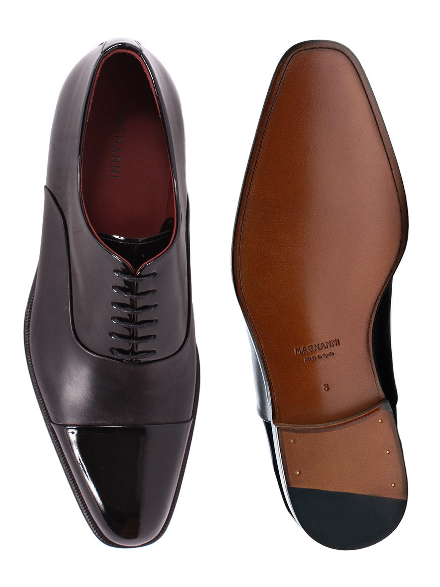 A pair of Magnanni Cesar in Black cap-toe oxford shoes on a white background.