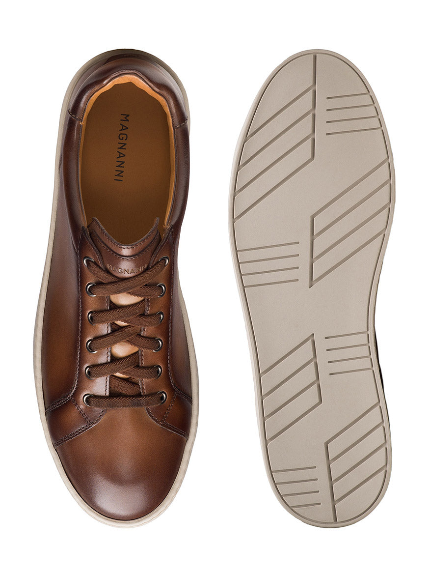 The Magnanni Cote Lo Stretch-Lace in Brown is a men’s low-top sneaker with tan laces, geometric rubber sole, and "MAGNANNI" on the insole—ideal as a stylish dress sneaker.