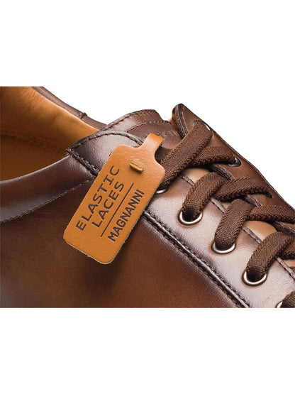 Close-up of the Magnanni Cote Lo Stretch-Lace in Brown, a men’s leather low-top sneaker with matching stretch laces and a leather tag, featuring a comfortable stretch-lace system for style and ease.