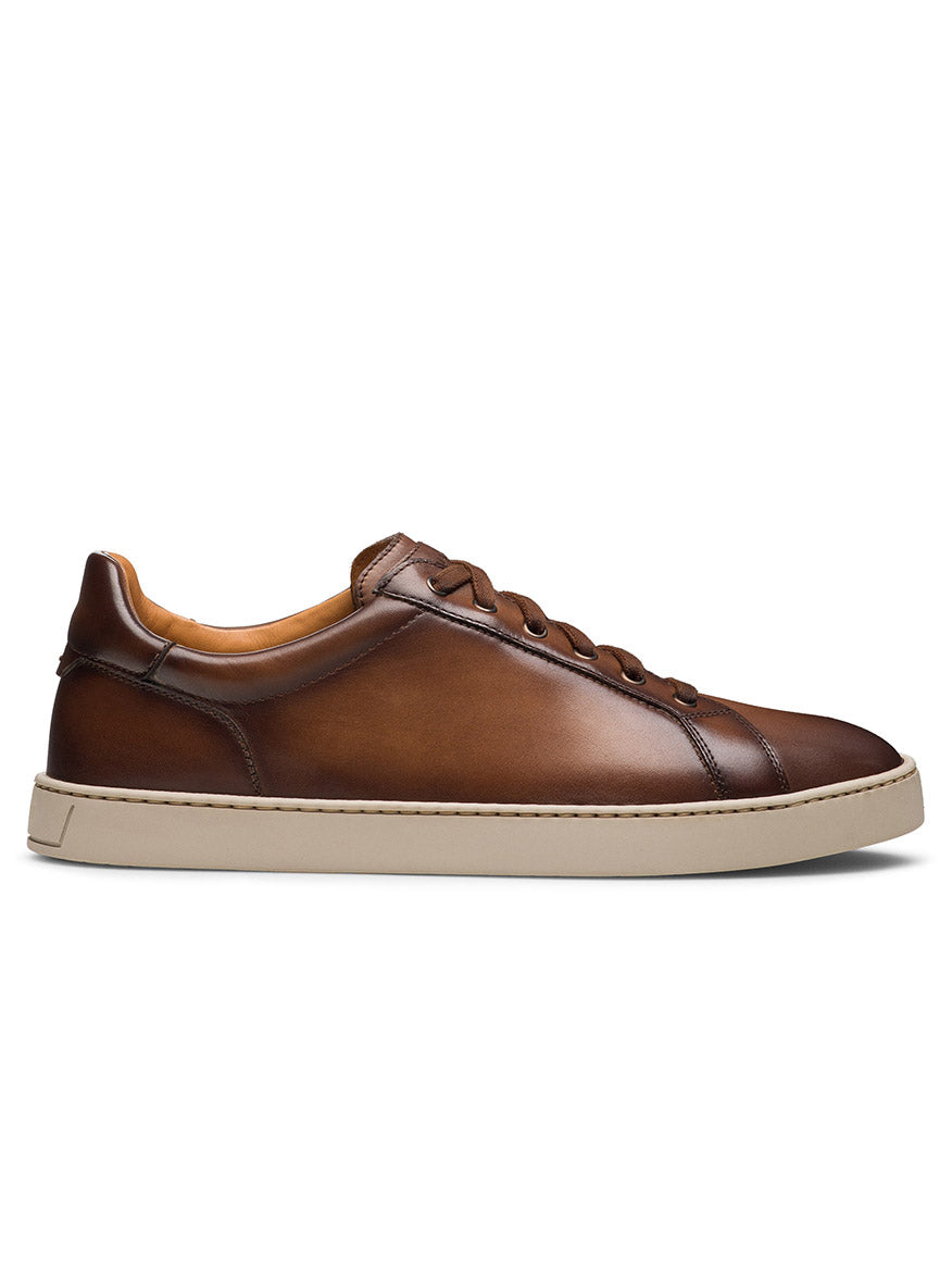 The Magnanni Cote Lo Stretch-Lace in Brown is a men's brown leather low-top sneaker with matching stretch laces and a white rubber sole, shown in a sleek side profile on a white background.