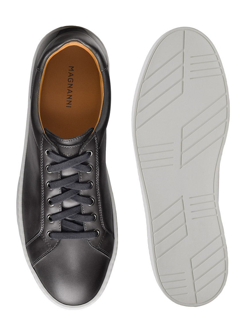 The Magnanni Cote Lo Stretch-Lace in Grey are black leather dress sneakers with a gray stretch-lace system and white rubber soles, displayed from top and bottom views.